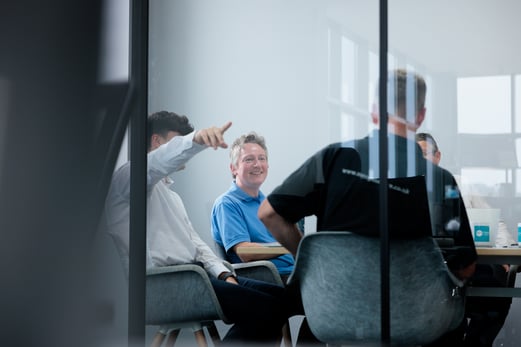 4 men sat at a table smiling